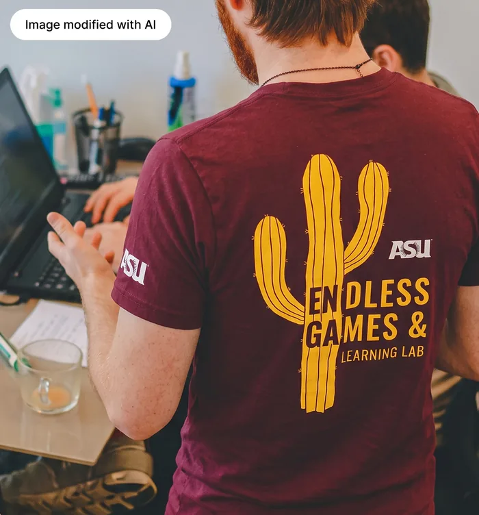 A person wearing the finished maroon shirt, its back printed with a gold saguaro cactus and “Endless Games & Learning Lab”, with ASU on the sleeve.